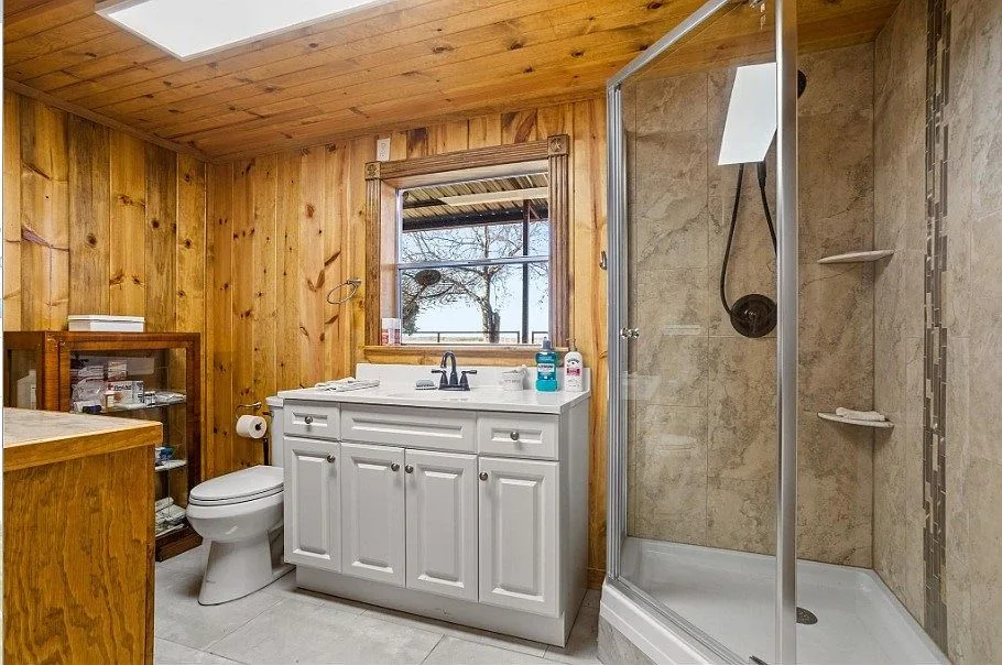 Bathroom with knotty pine walls and white vanity