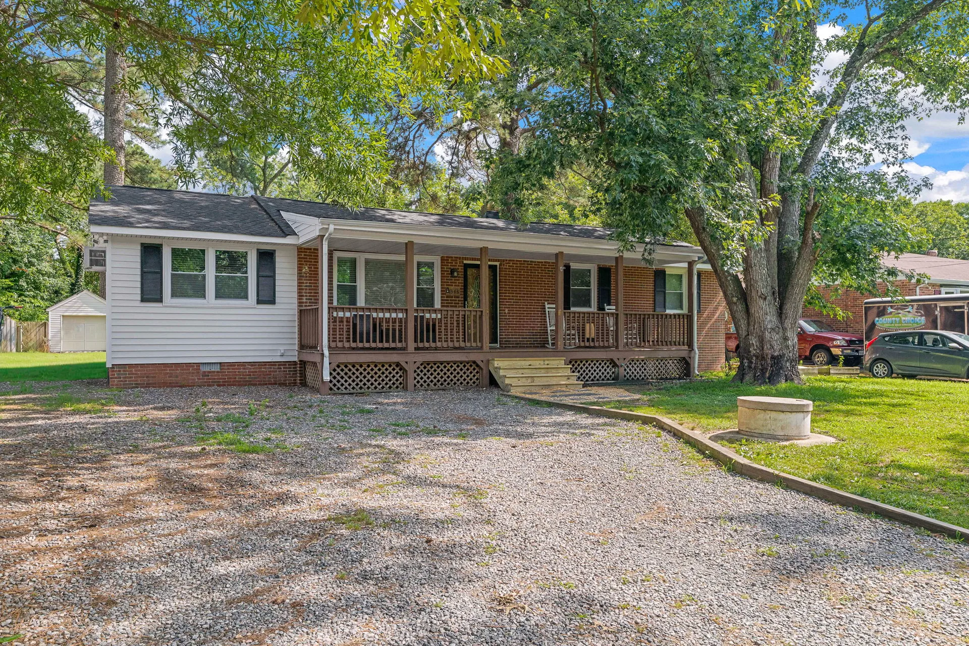 Front facade in bright daylight with white siding and covered porch
