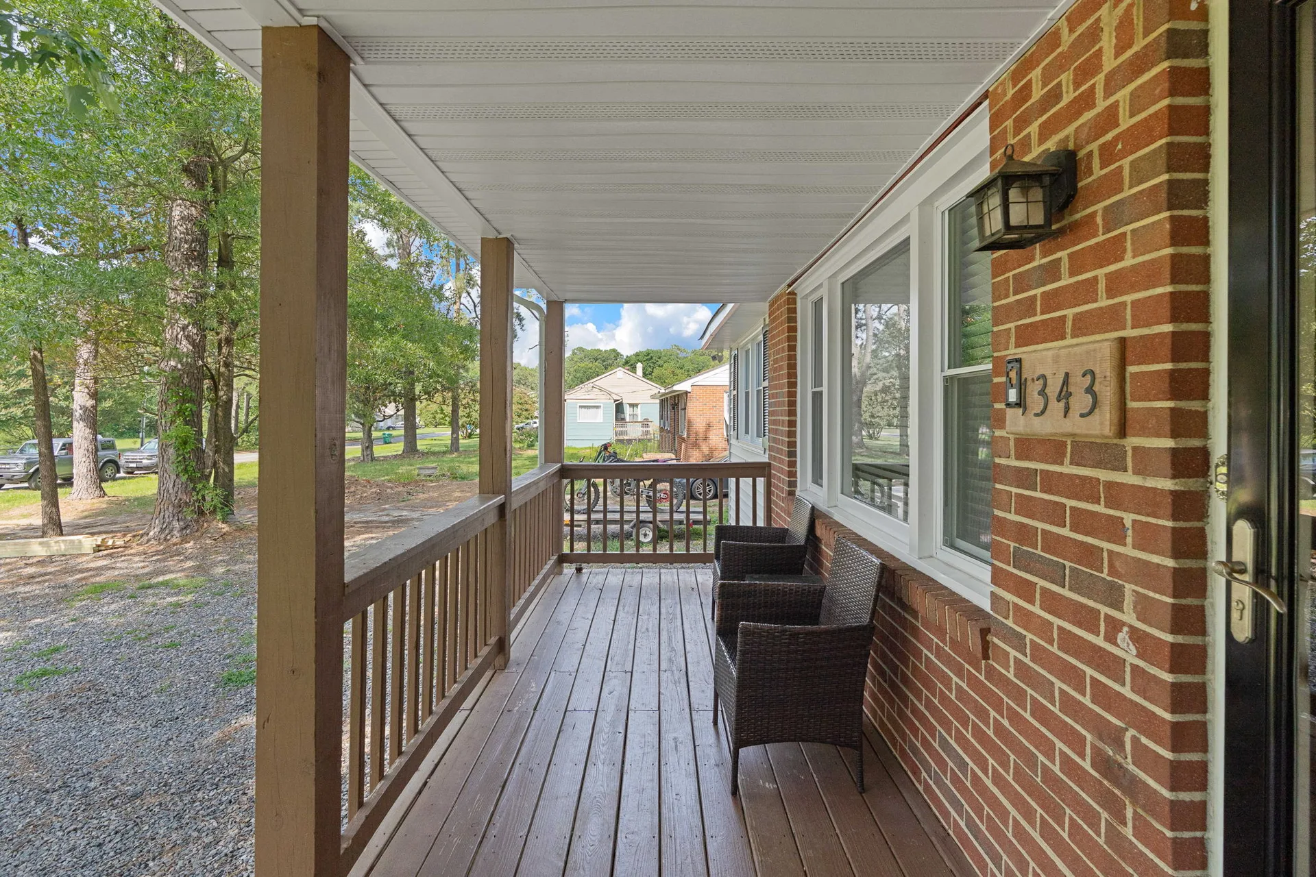 Front porch with brick exterior and wicker seating