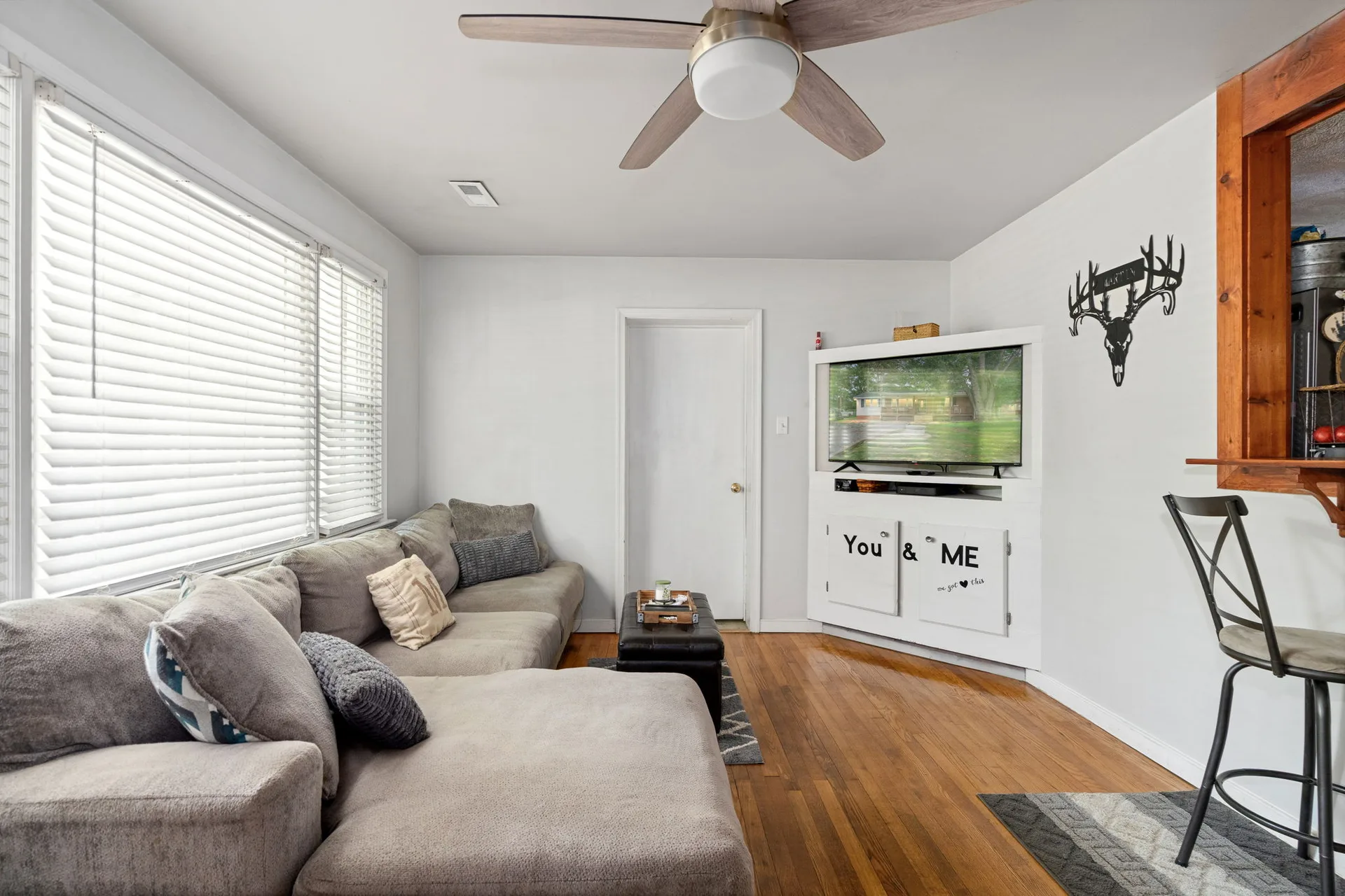 Living room with built-in entertainment center and hardwood flooring