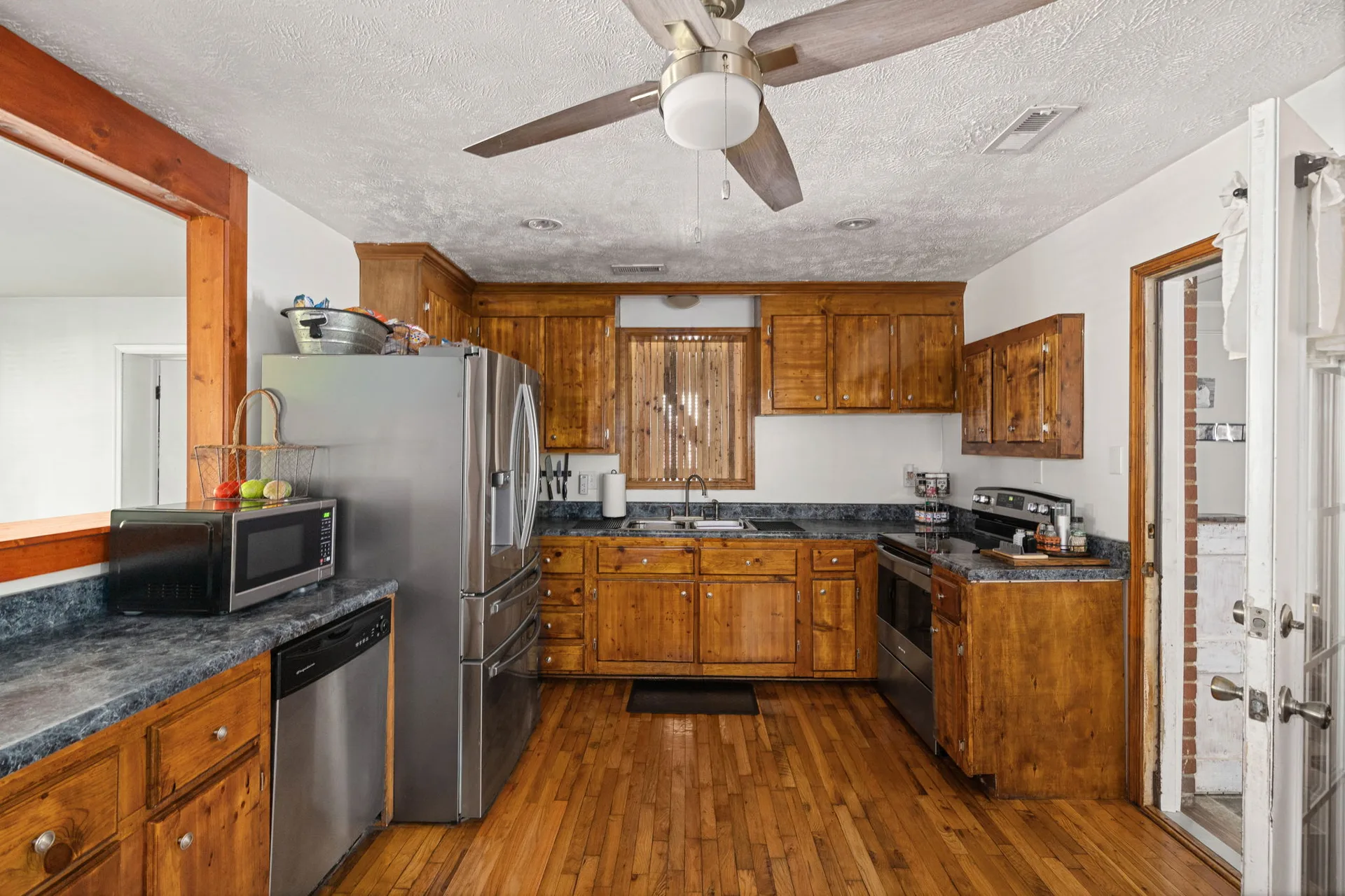 Kitchen with honey-toned wood cabinets and dark laminate counters