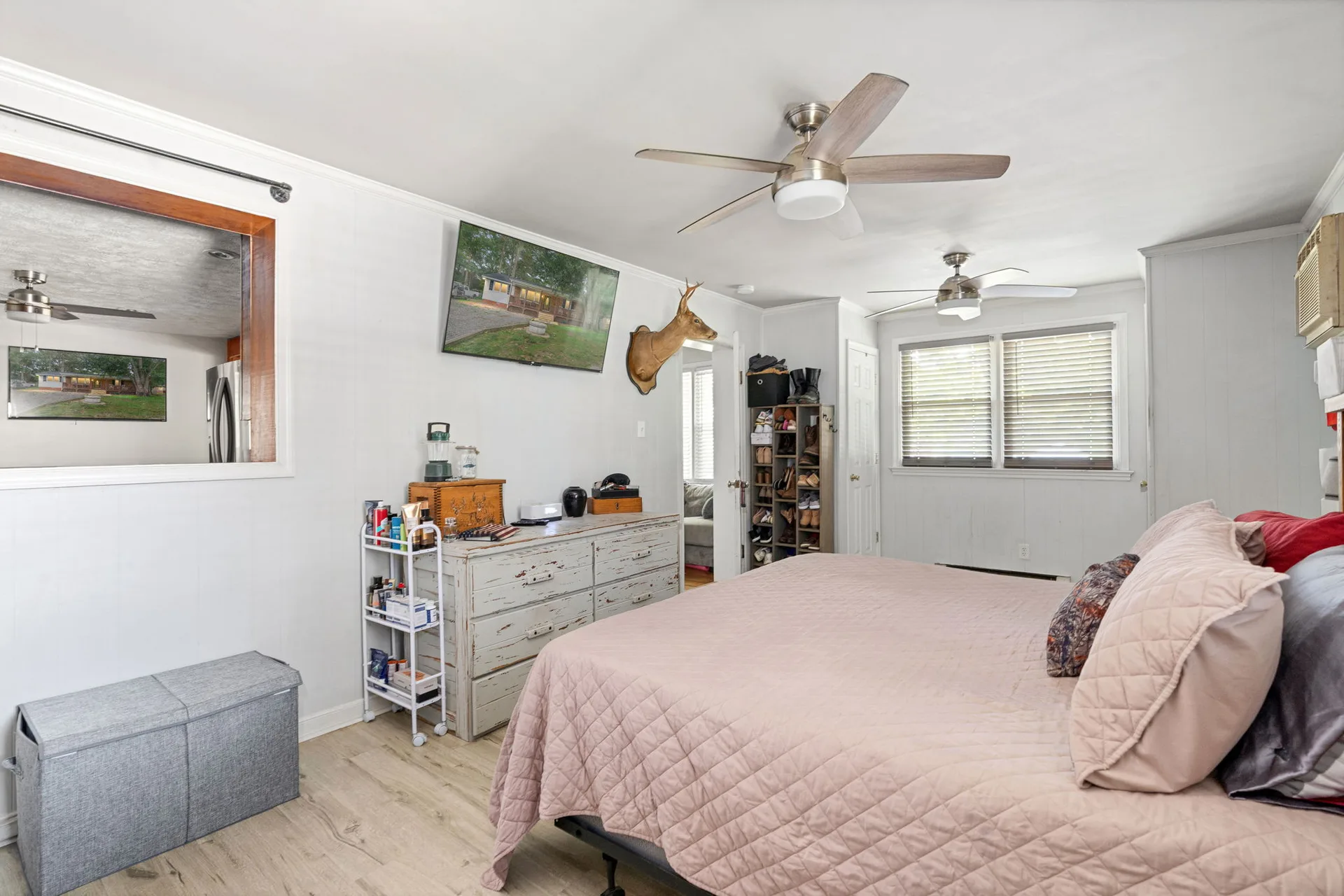 Primary bedroom with light wood-look vinyl flooring