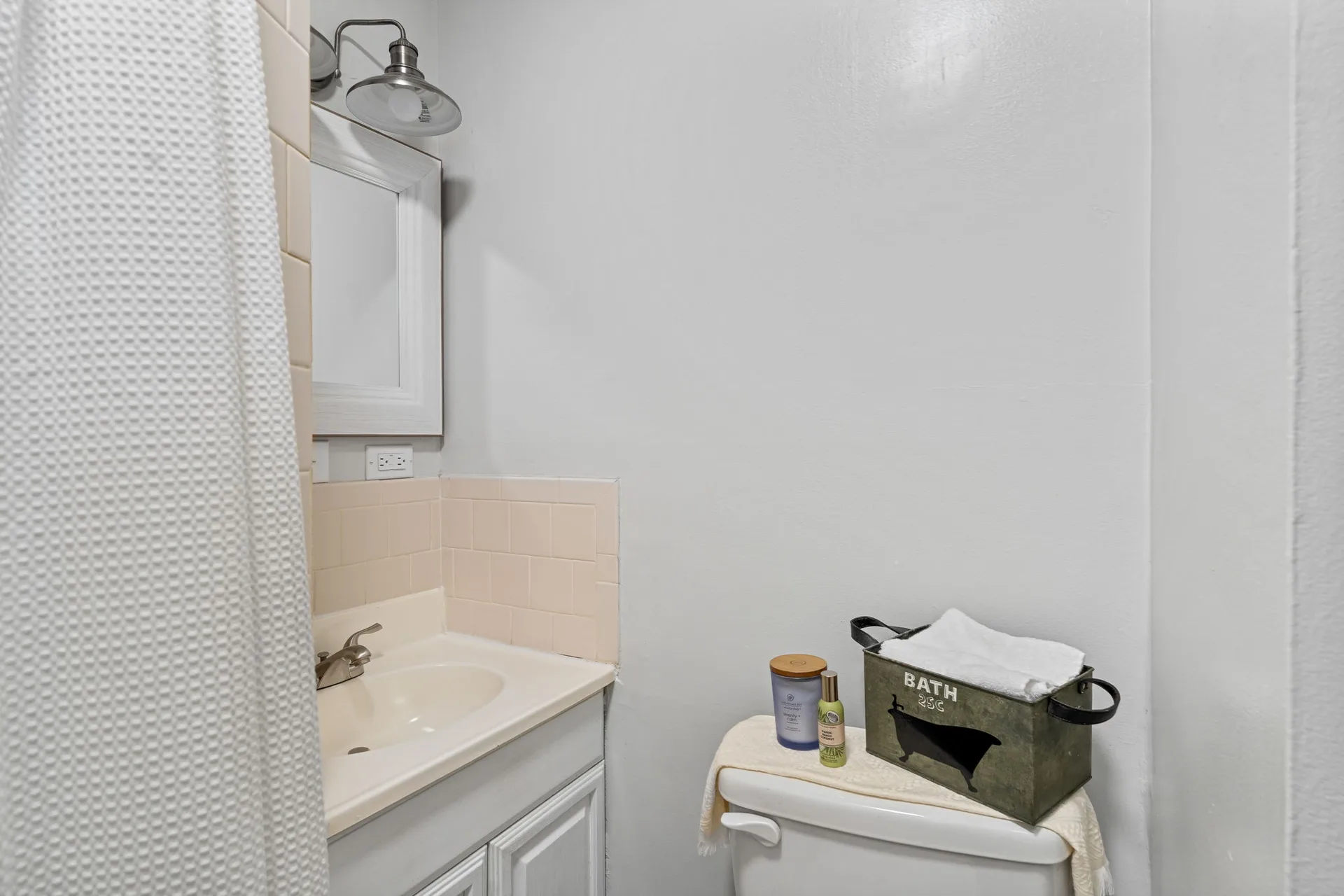 Bathroom vanity with white cabinet and beige tile backsplash