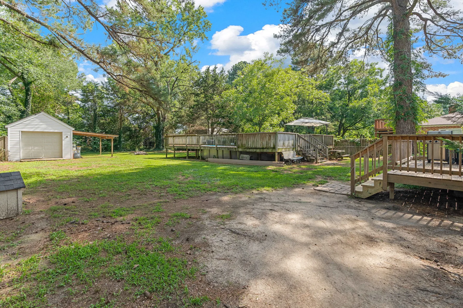 Ground-level view of pool deck and detached outbuilding