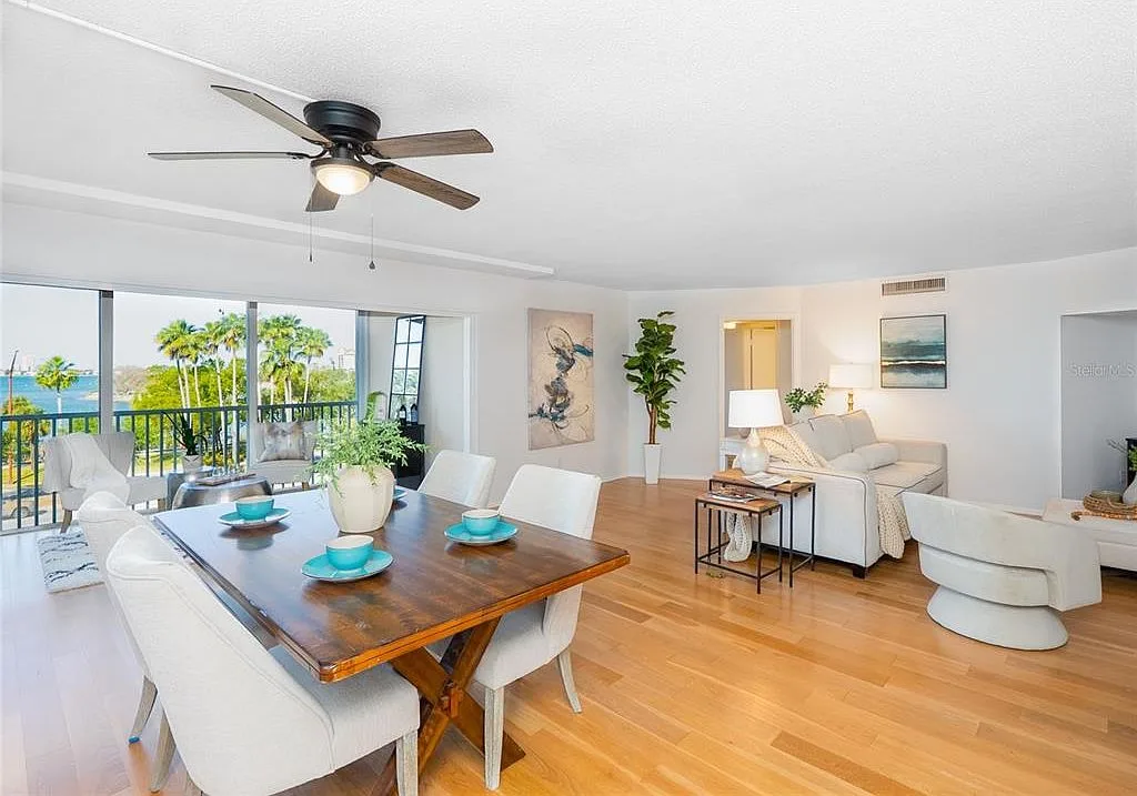 Open-plan living and dining area with floor-to-ceiling bay views