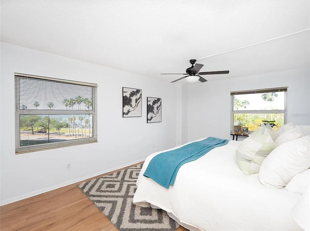 Primary bedroom with bay views and palm trees through windows