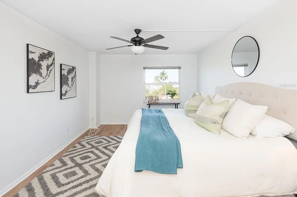 Primary bedroom with tufted headboard and warm lighting