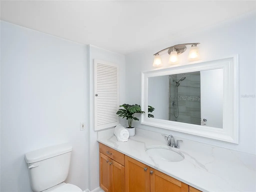 Updated bathroom with wood vanity and quartz countertop