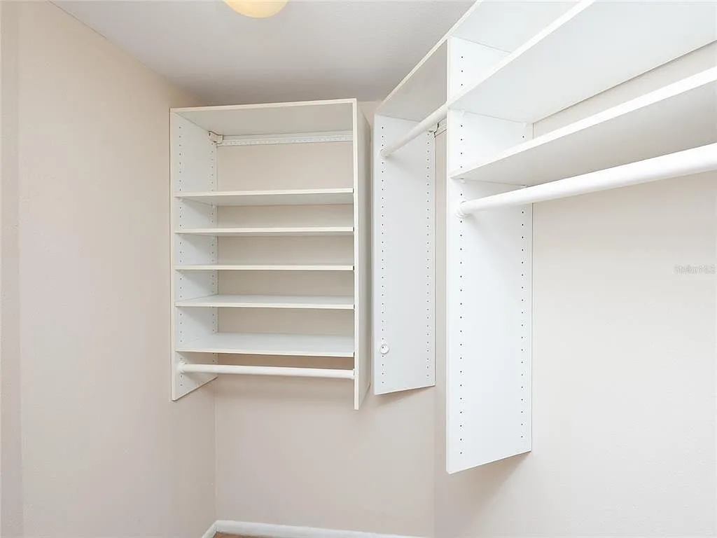 Walk-in closet with white modular shelving system