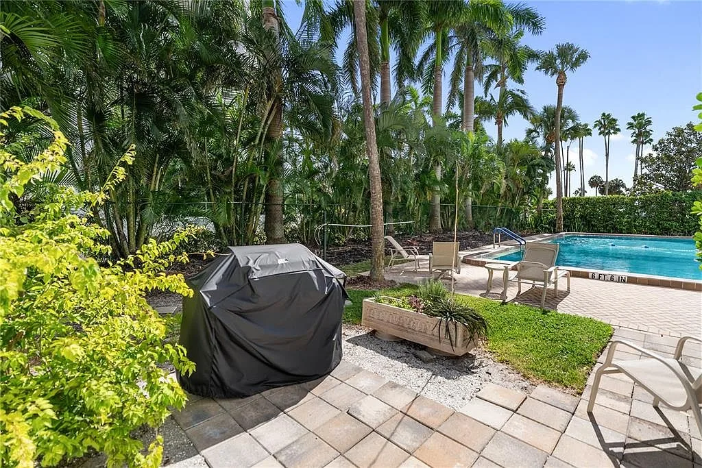 Community pool and patio area with palm trees