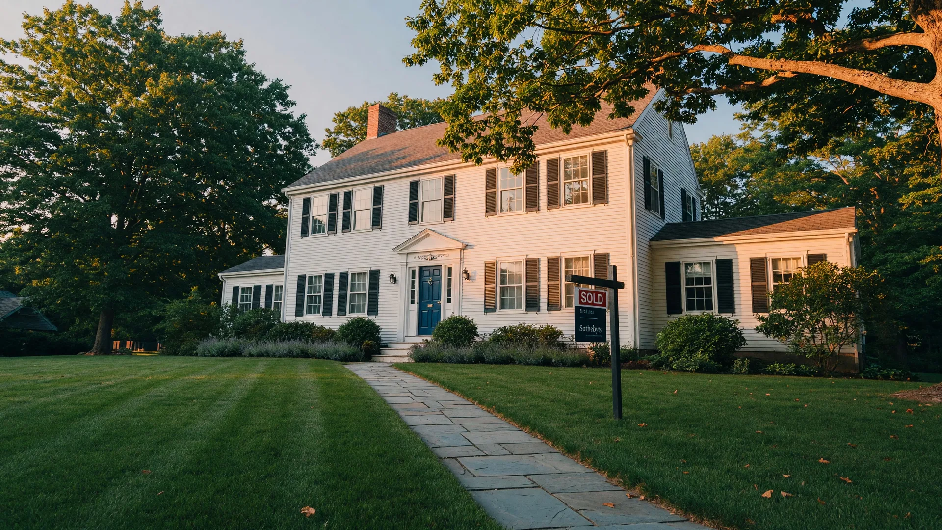 A classic New England colonial home in Connecticut with a SOLD sign on the front lawn