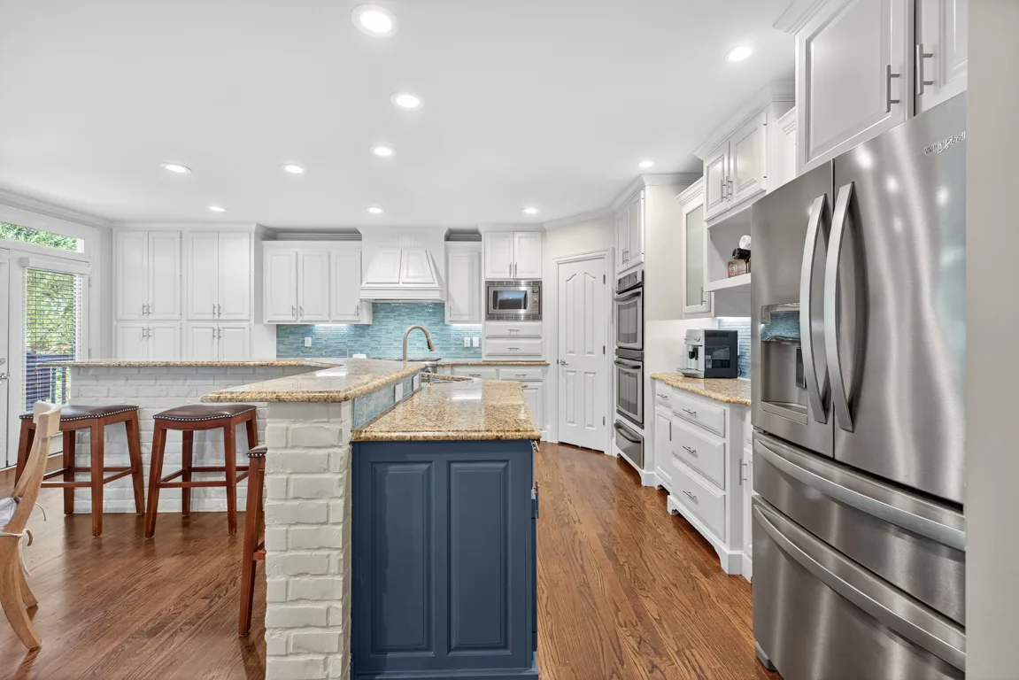Kitchen wide shot with blue island and white brick base
