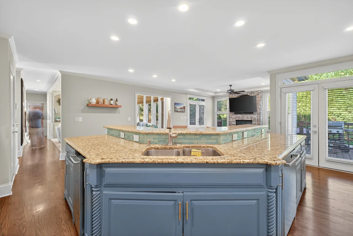 Kitchen from island facing living area with herringbone tile