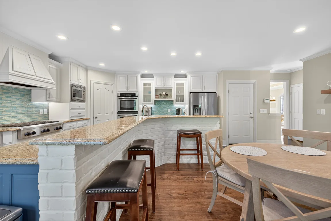 Kitchen with blue lower cabinets and white brick breakfast bar