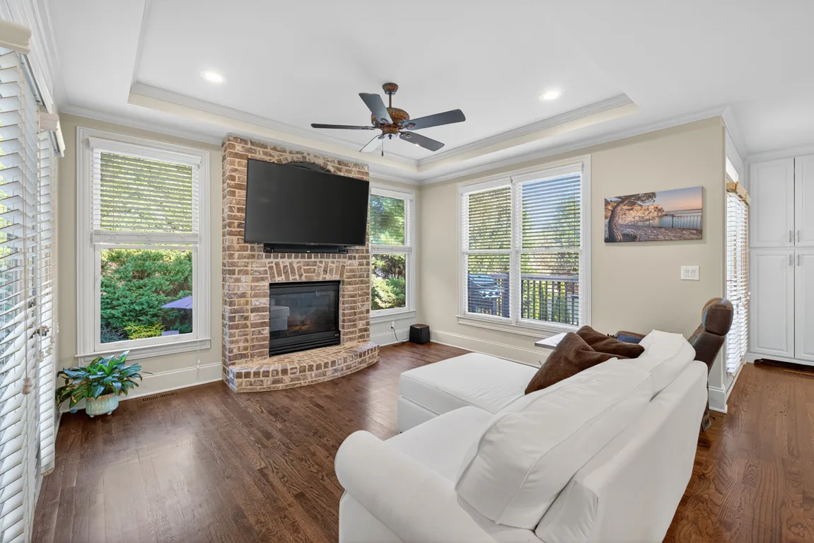 Living room with brick fireplace and tray ceiling