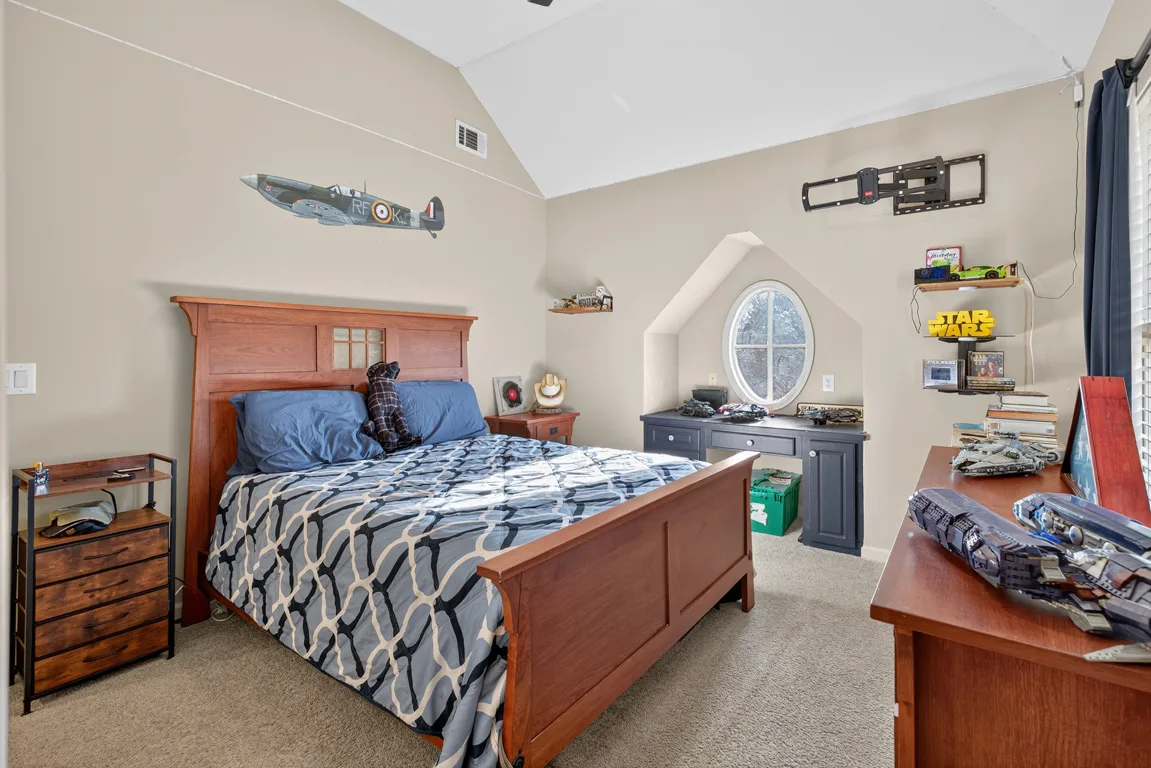 Kids bedroom with vaulted ceiling and oval window