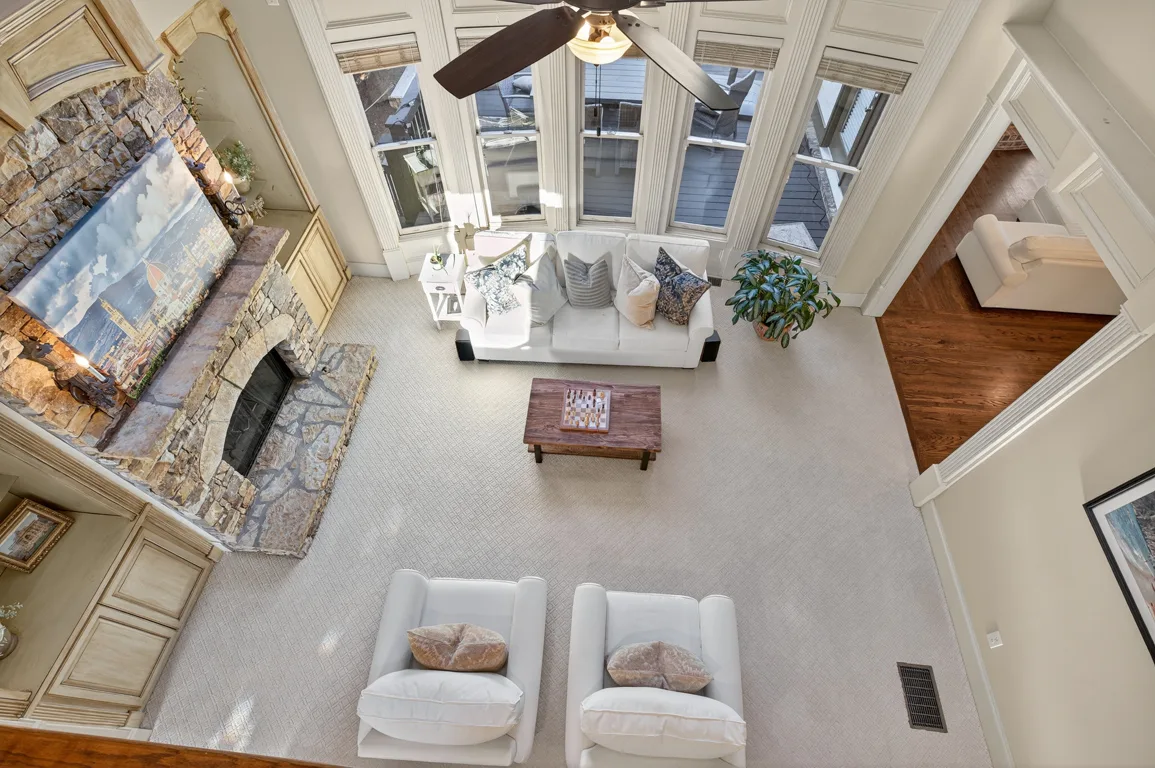 Living room from elevated mezzanine angle showing stone fireplace