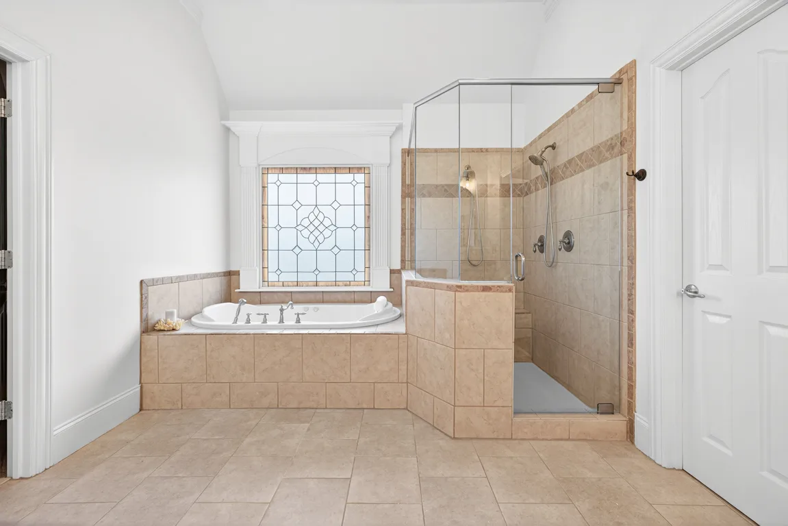 Master bathroom with corner tub and glass-enclosed shower
