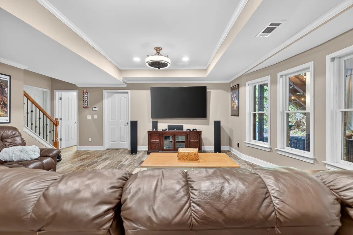 Basement living room with crown molding and tray ceiling
