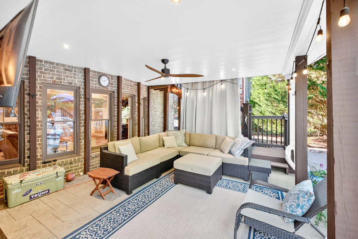 Covered brick patio with string lights and outdoor lounge