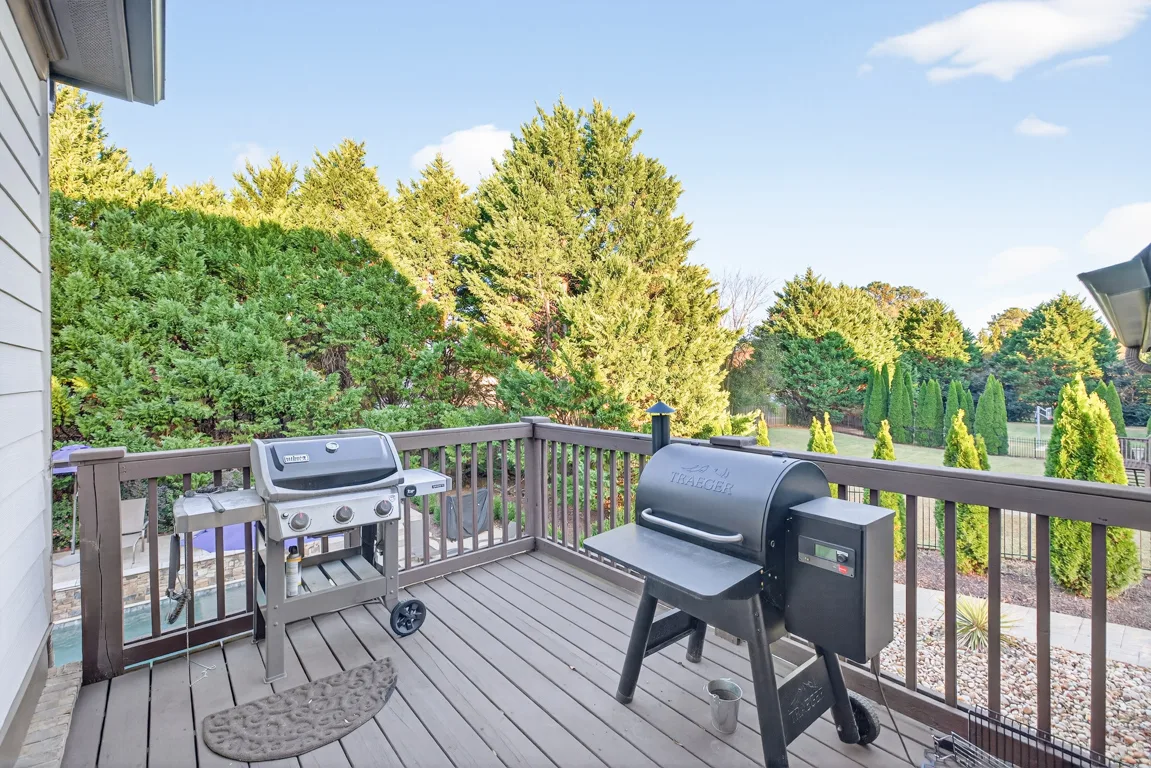 Deck view with grill setup overlooking green landscaping