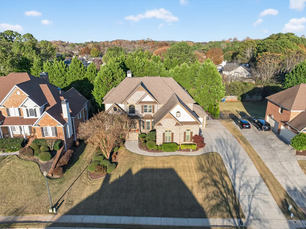 Aerial drone view of the property showing roofline and front yard