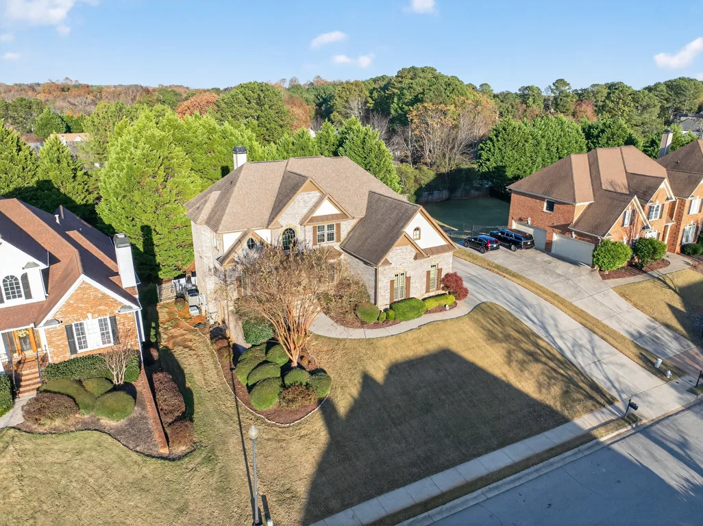 Elevated drone shot showing multi-gabled roofline and surrounding homes