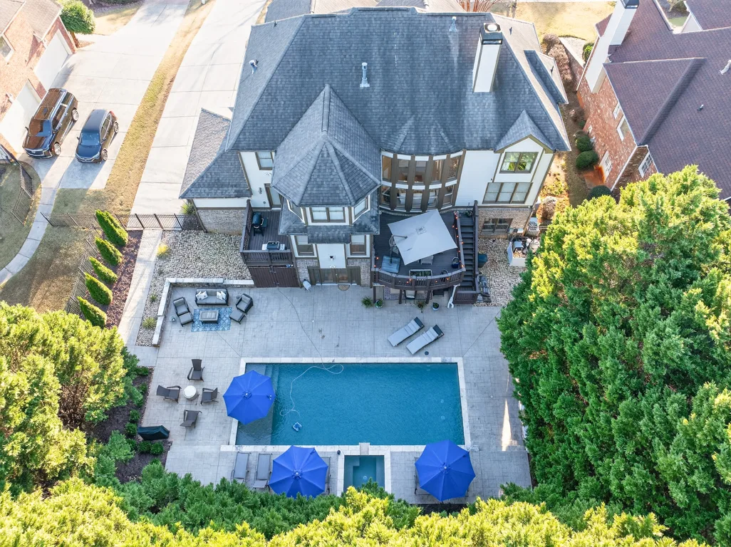 Aerial drone shot of the rear of the property with pool and patio