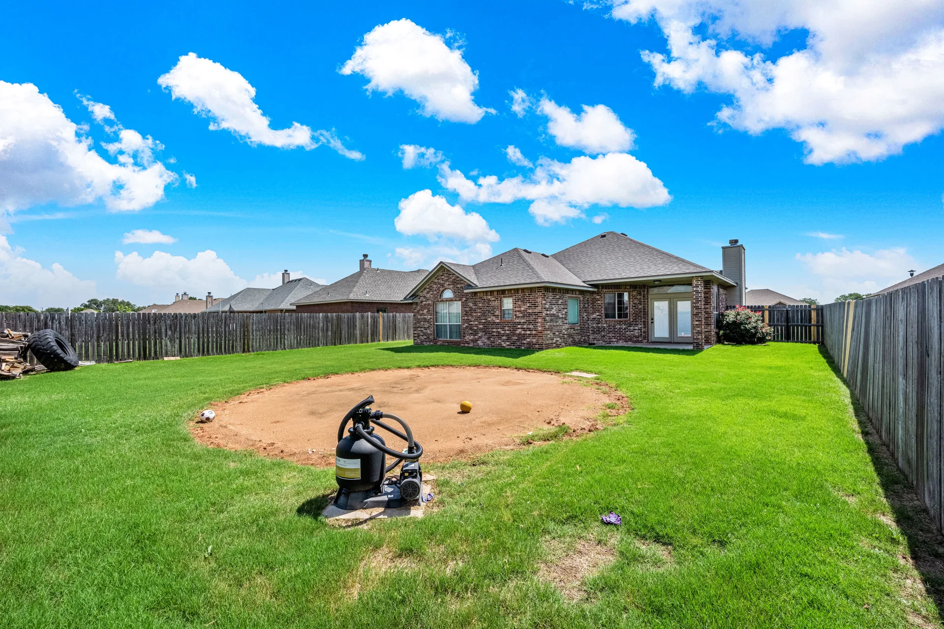 Fenced backyard with large lawn area