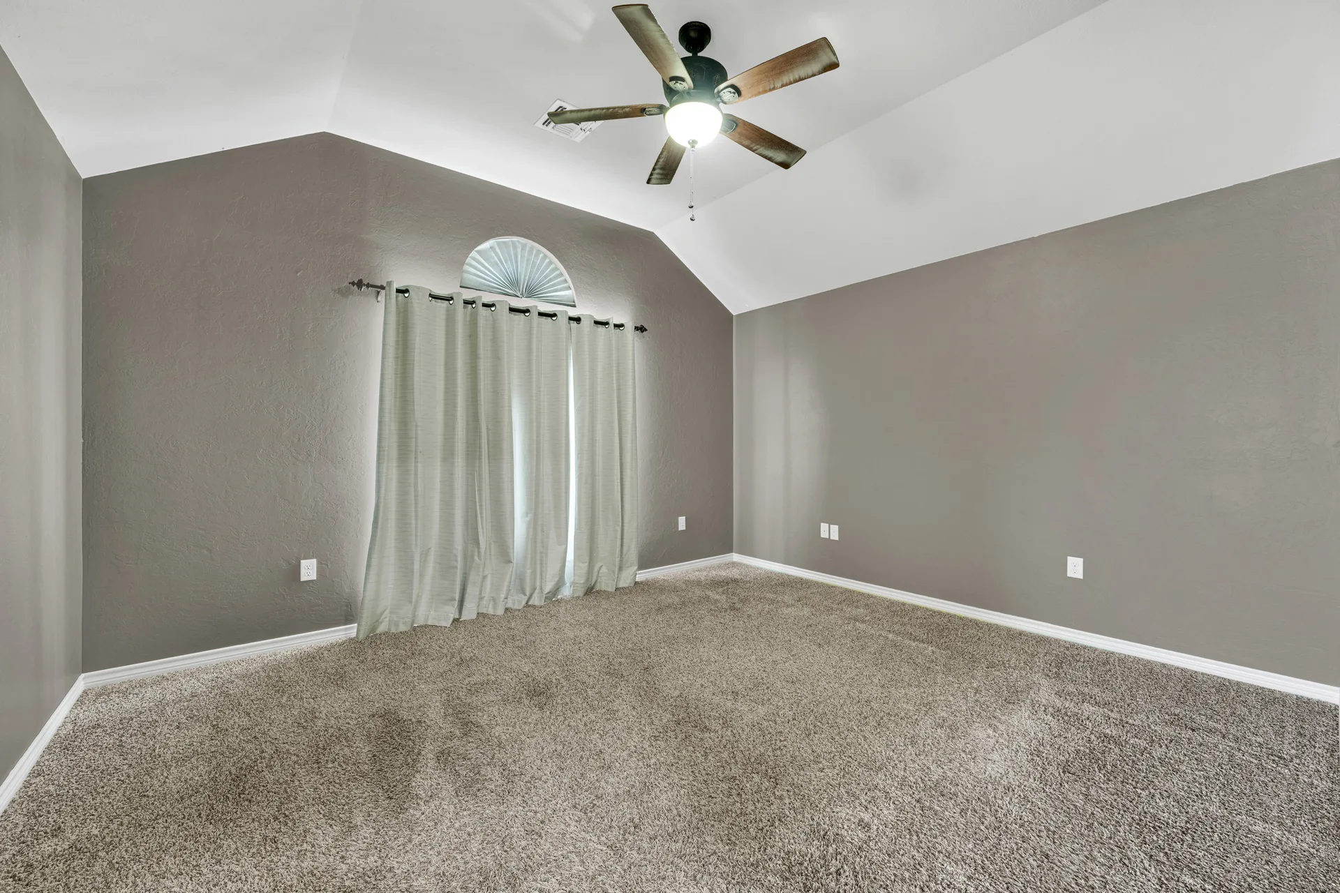 Open living area with vaulted ceilings and gray walls