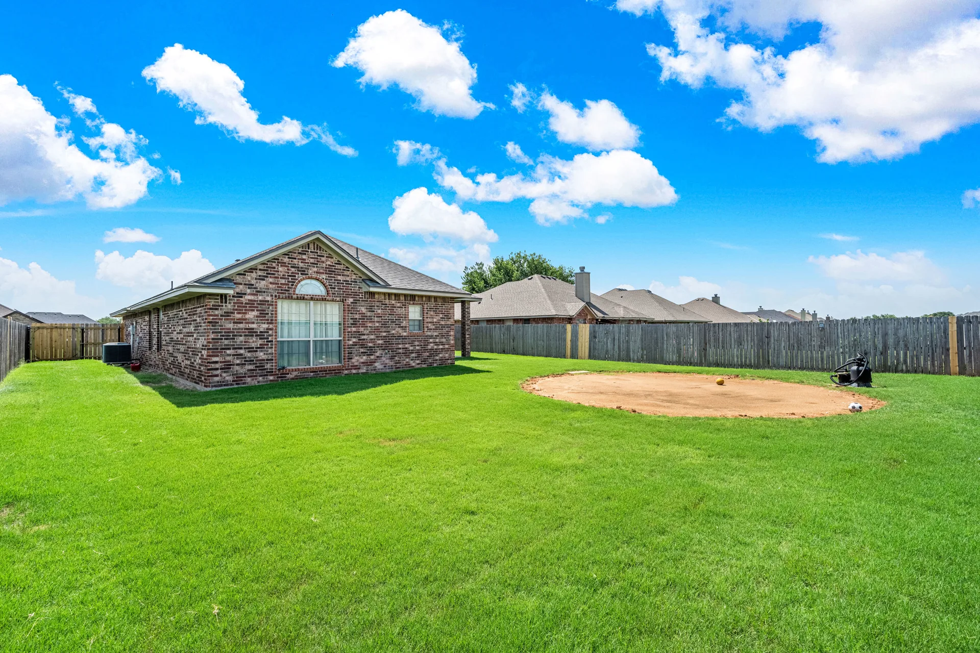 Backyard lawn with tall wood perimeter fence