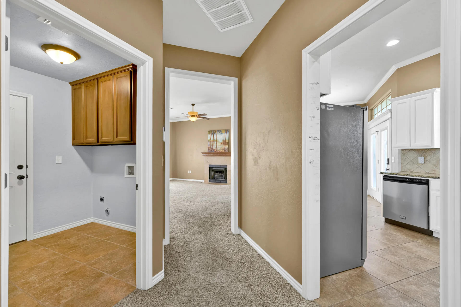 Hallway showing transitions between rooms with tile and carpet