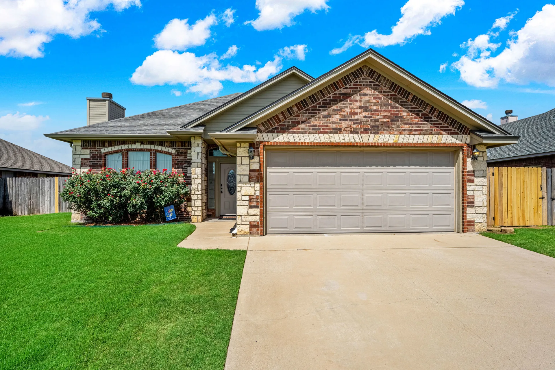 Street-level view of the front exterior of 408 Mountain Meadow Dr in Cache Oklahoma with double driveway and garage