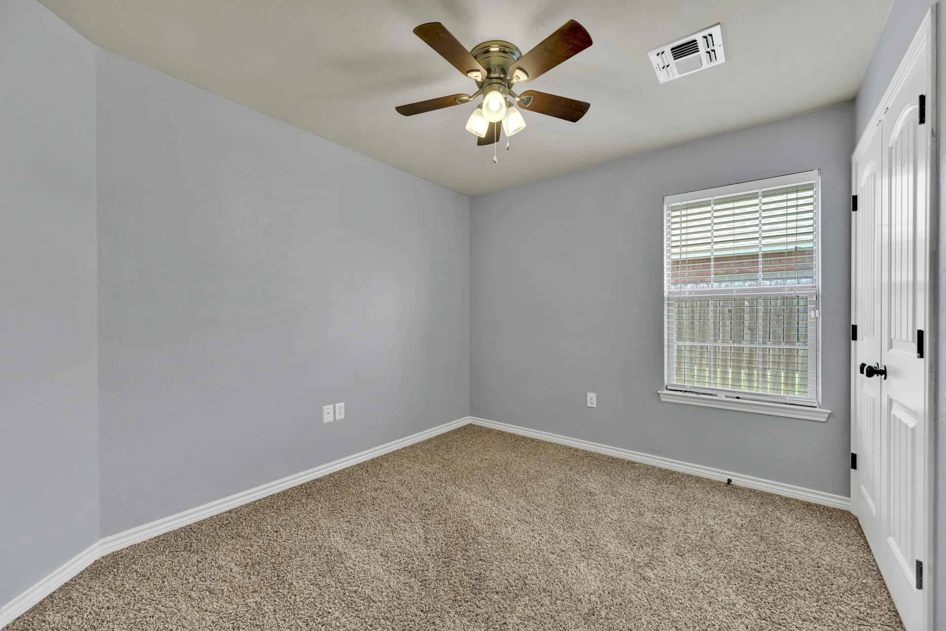 Secondary bedroom with light grey walls and daylight