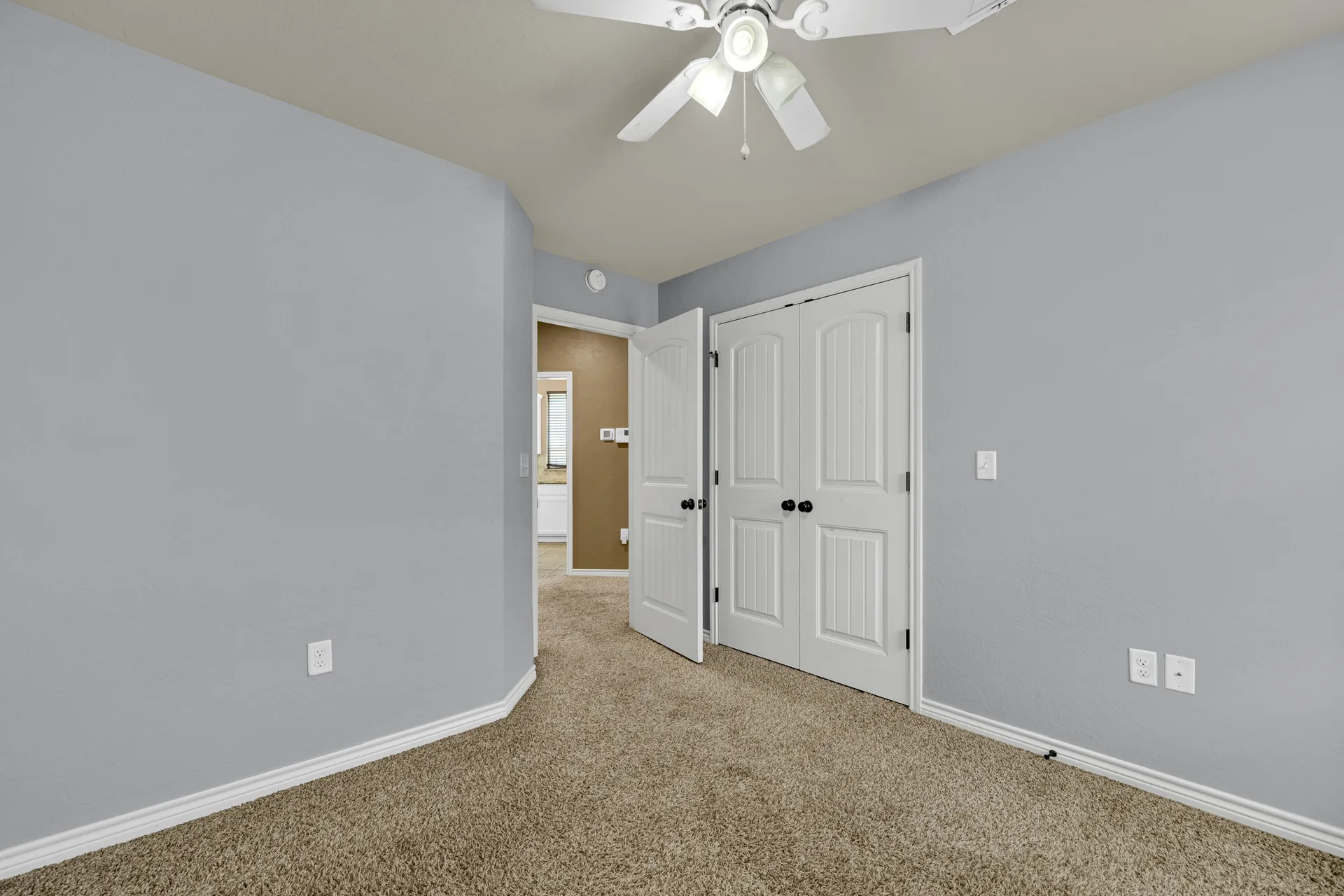 Bedroom with entry door, closet, and ceiling fan