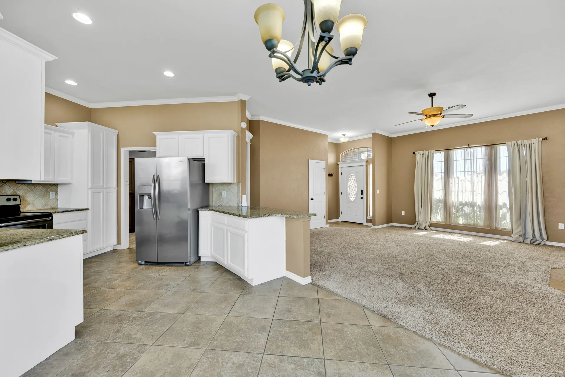 Open-concept kitchen and living area with white cabinetry