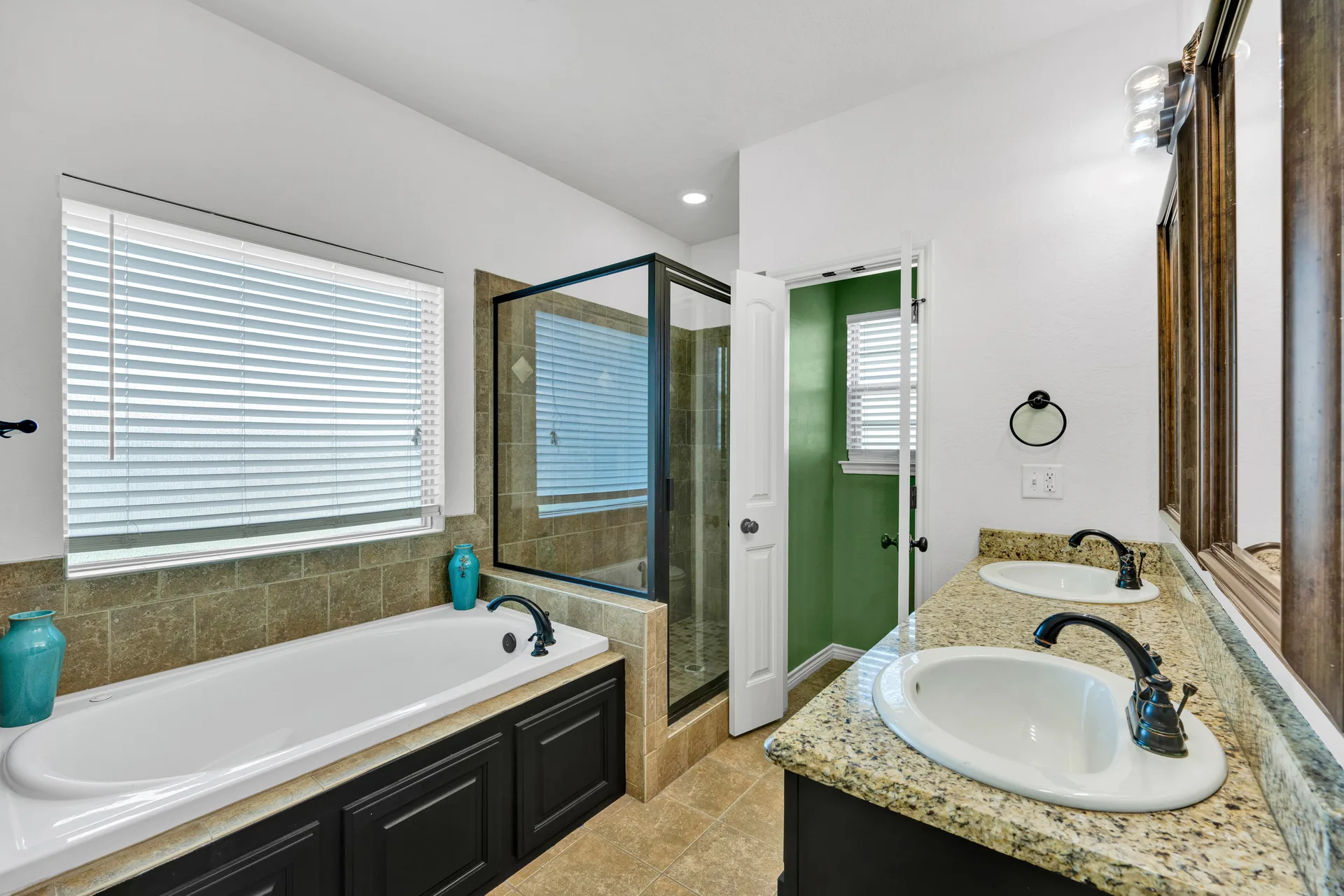 Primary bathroom with dual vanity sinks and granite countertops