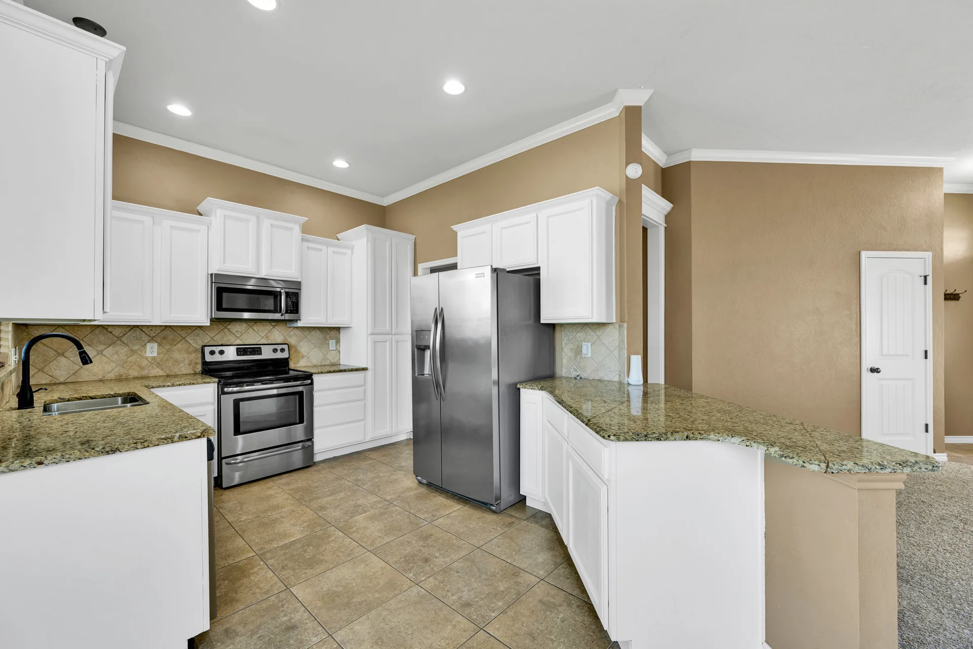 Kitchen with white shaker cabinets and granite countertops