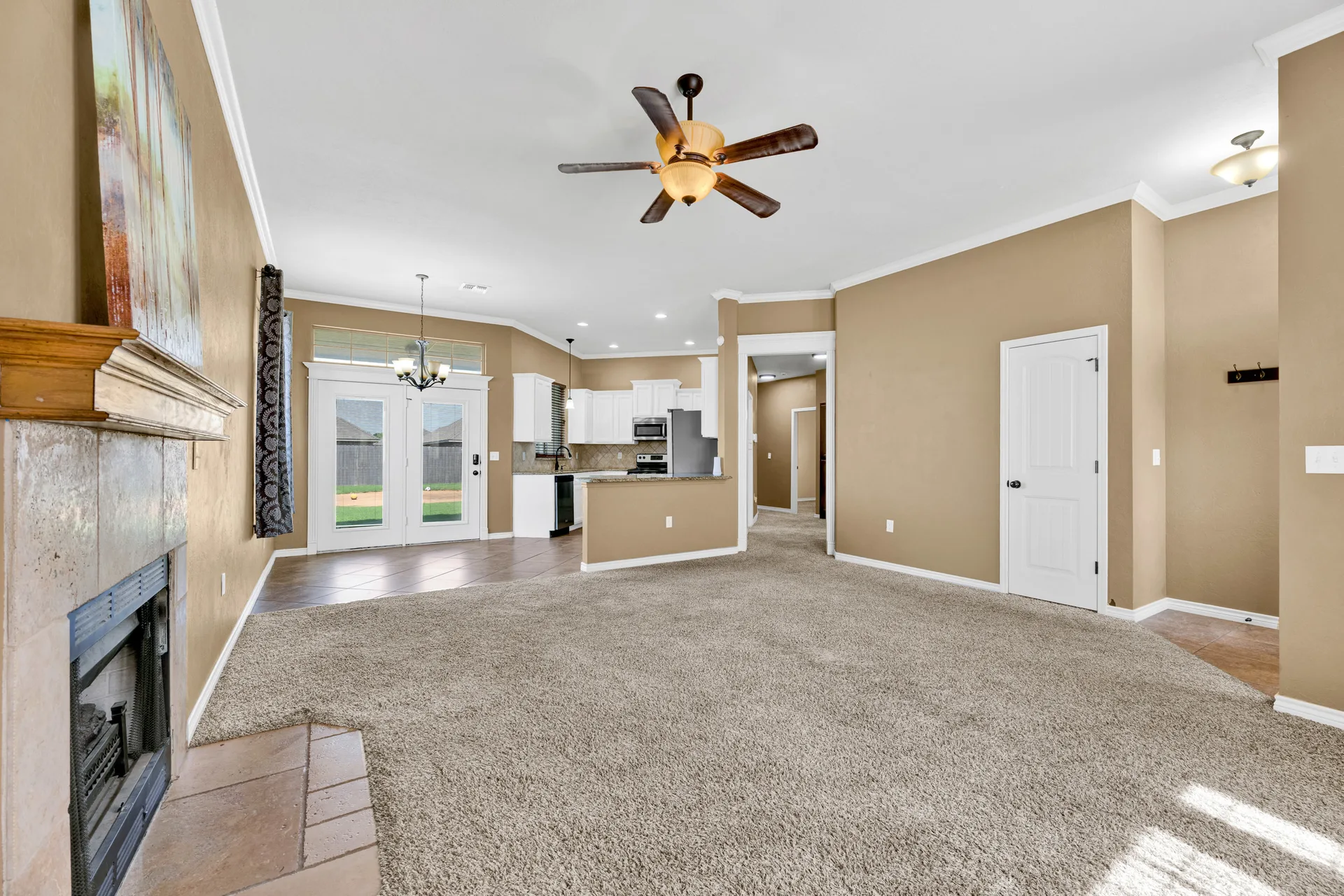 Open-concept living and kitchen with tile fireplace surround