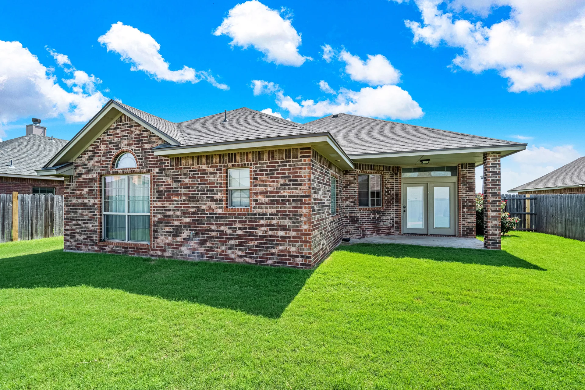 Backyard with covered patio and brick exterior