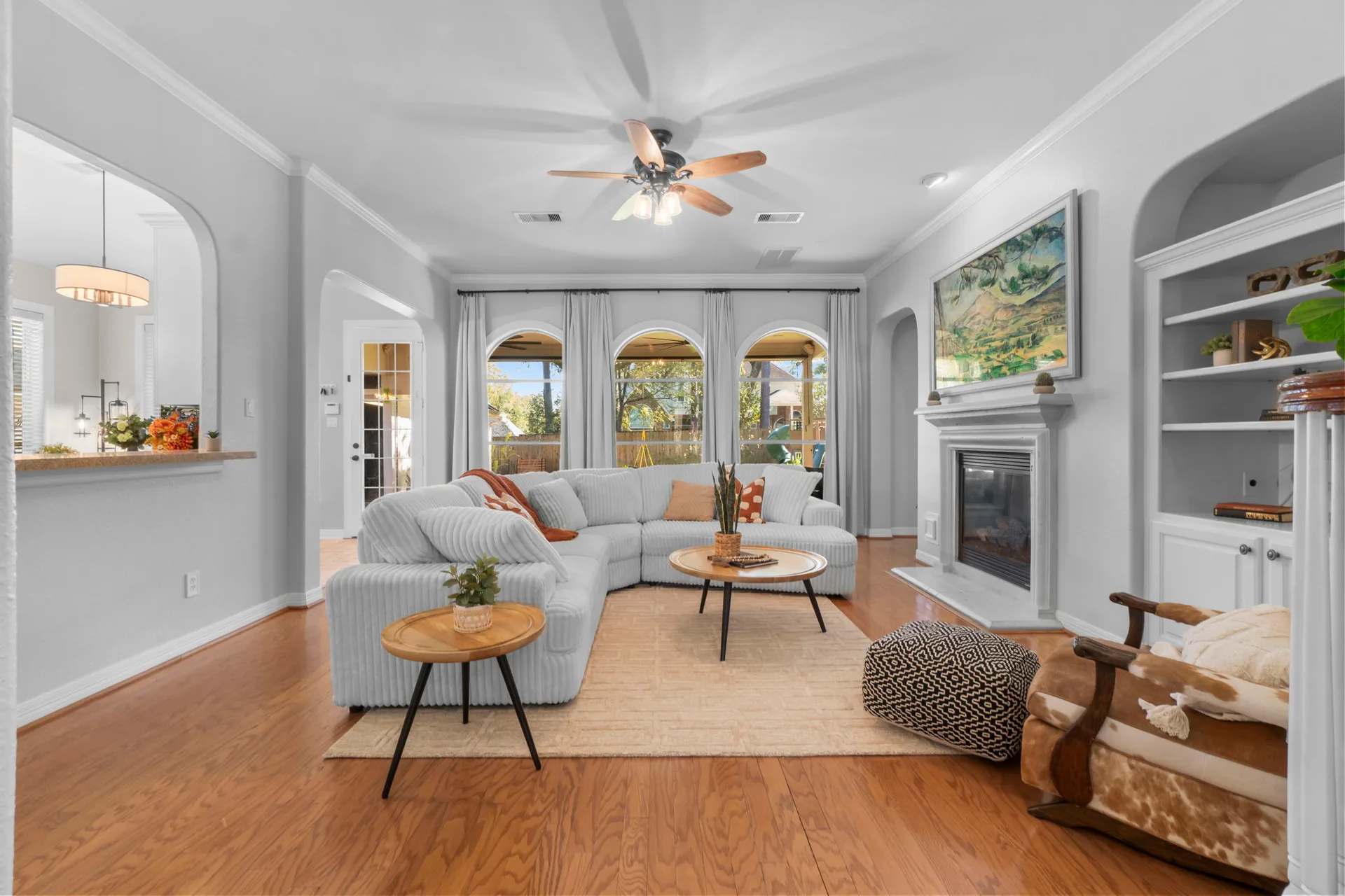 Living room with arched built-ins and fireplace with hardwood floors