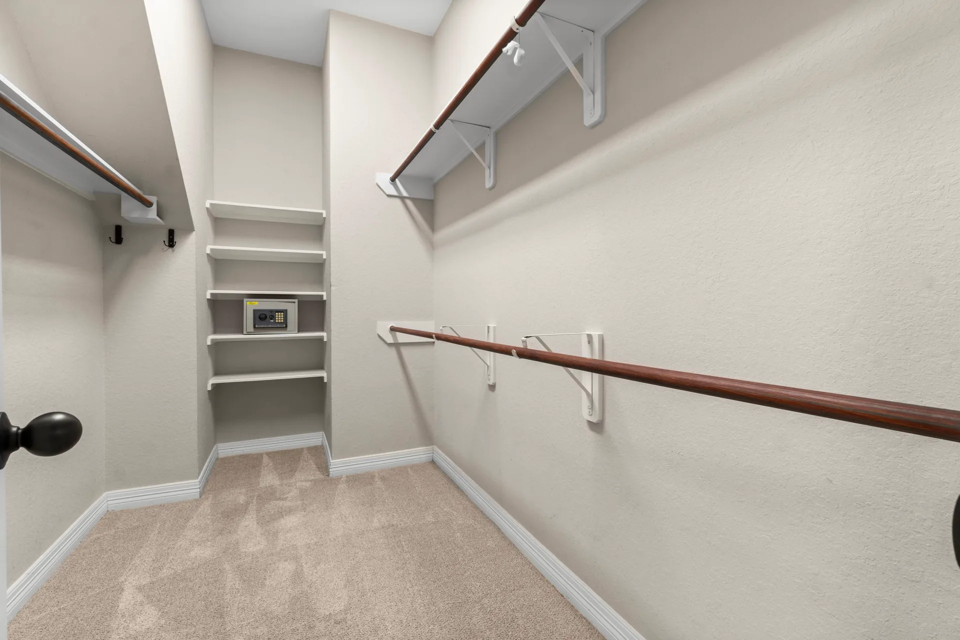 Walk-in closet with wood rod and white wire shelving hardware