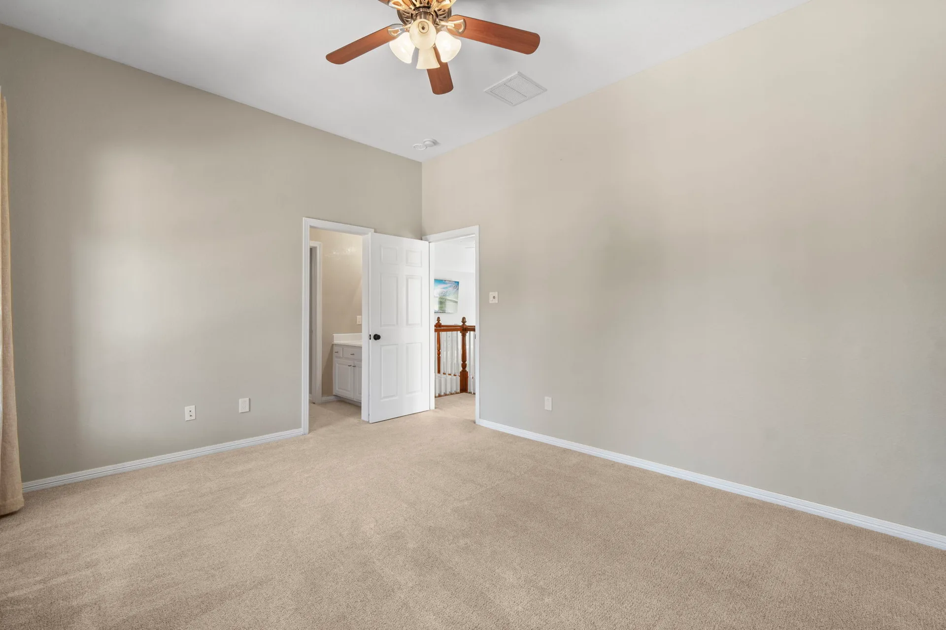 Primary bedroom vacant with beige walls and neutral wall-to-wall carpeting