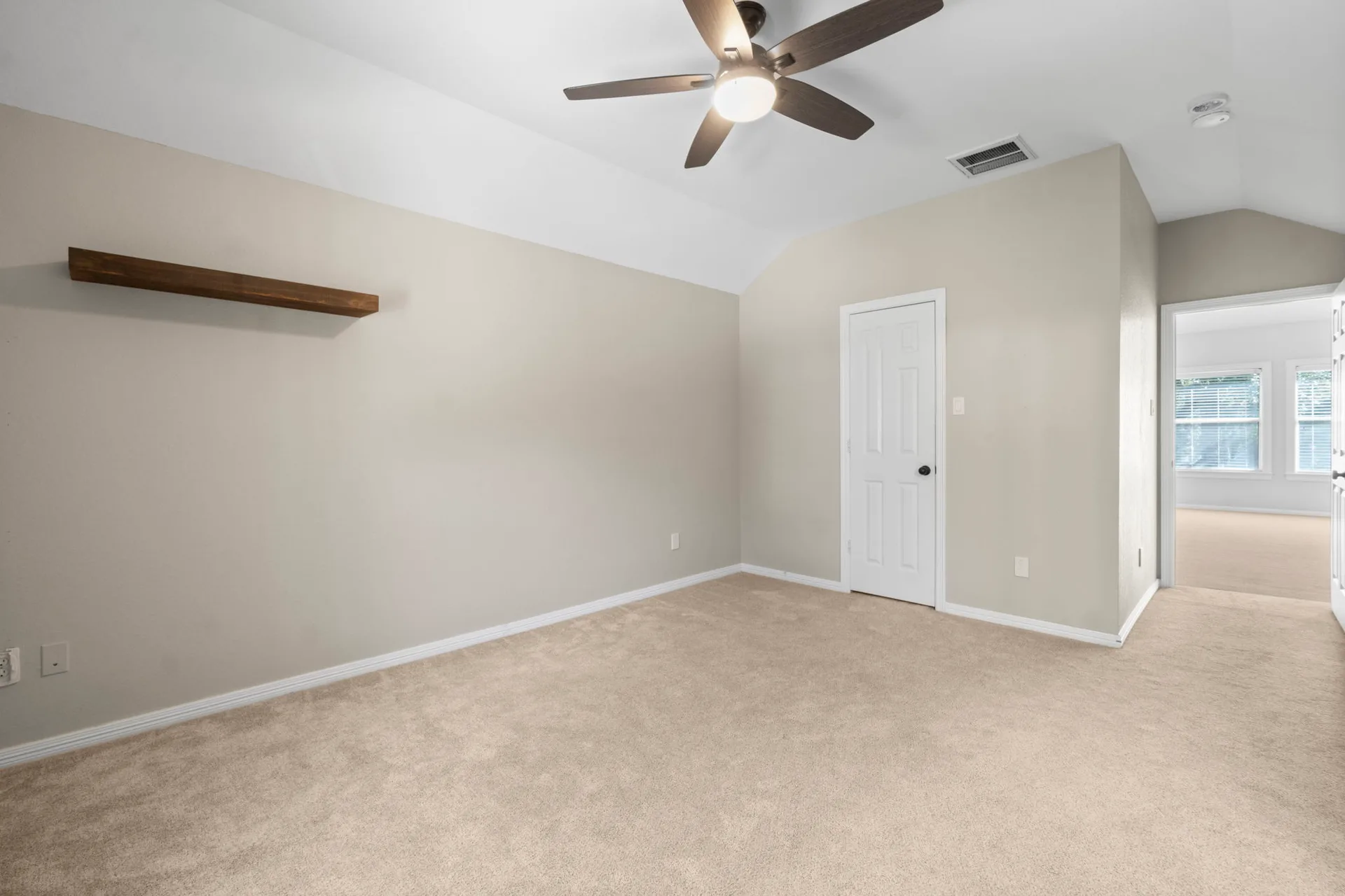 Secondary bedroom with carpet flooring, neutral walls, and vaulted ceiling