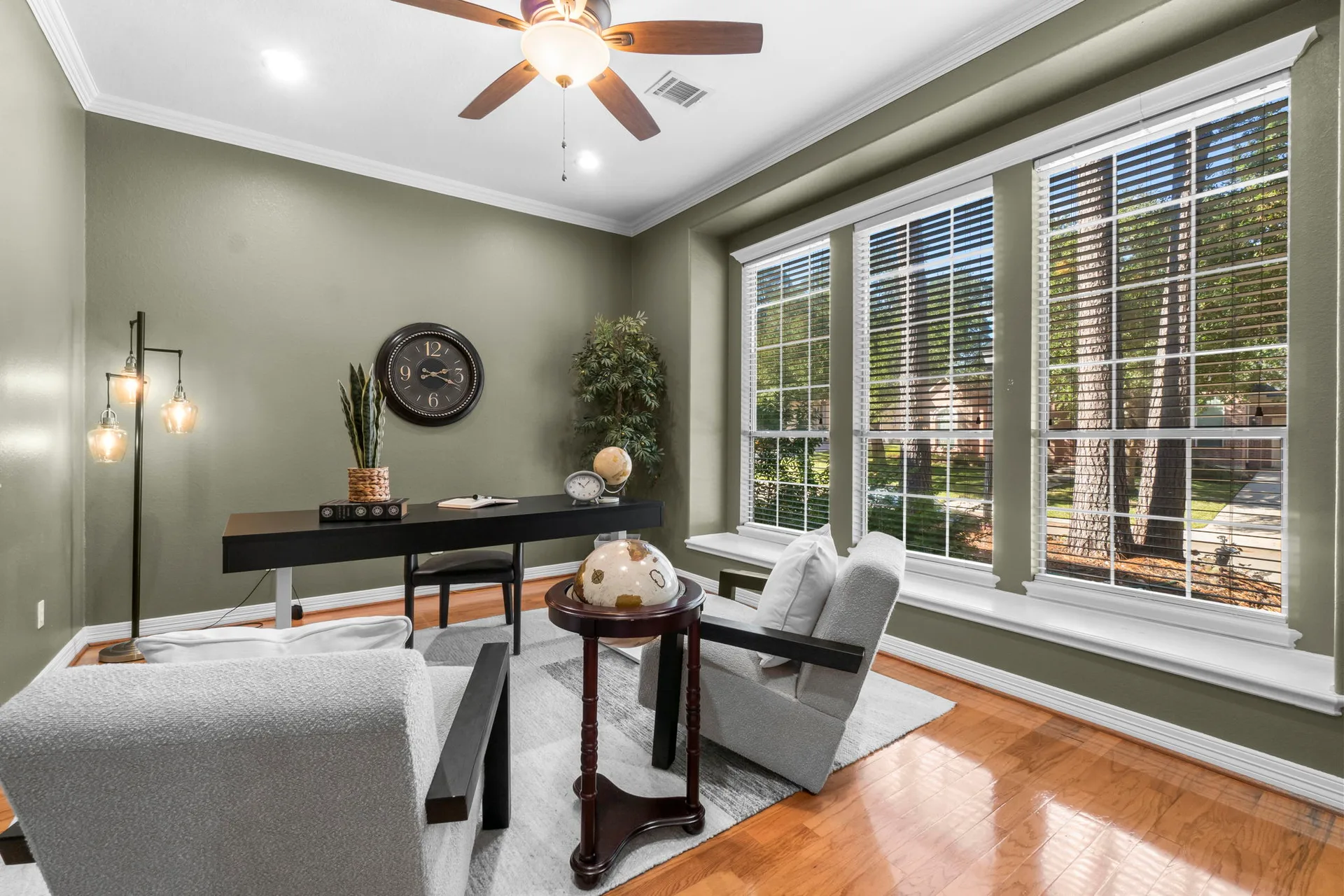 Office or study with sage green walls, hardwood floors, and large windows