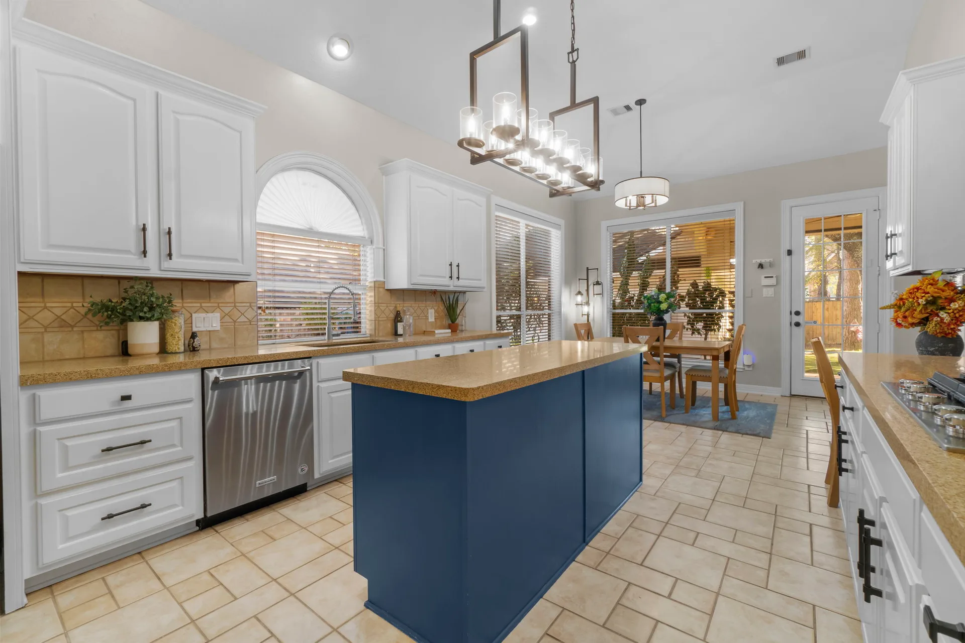 Kitchen and dining area with white raised-panel cabinetry and navy blue center island