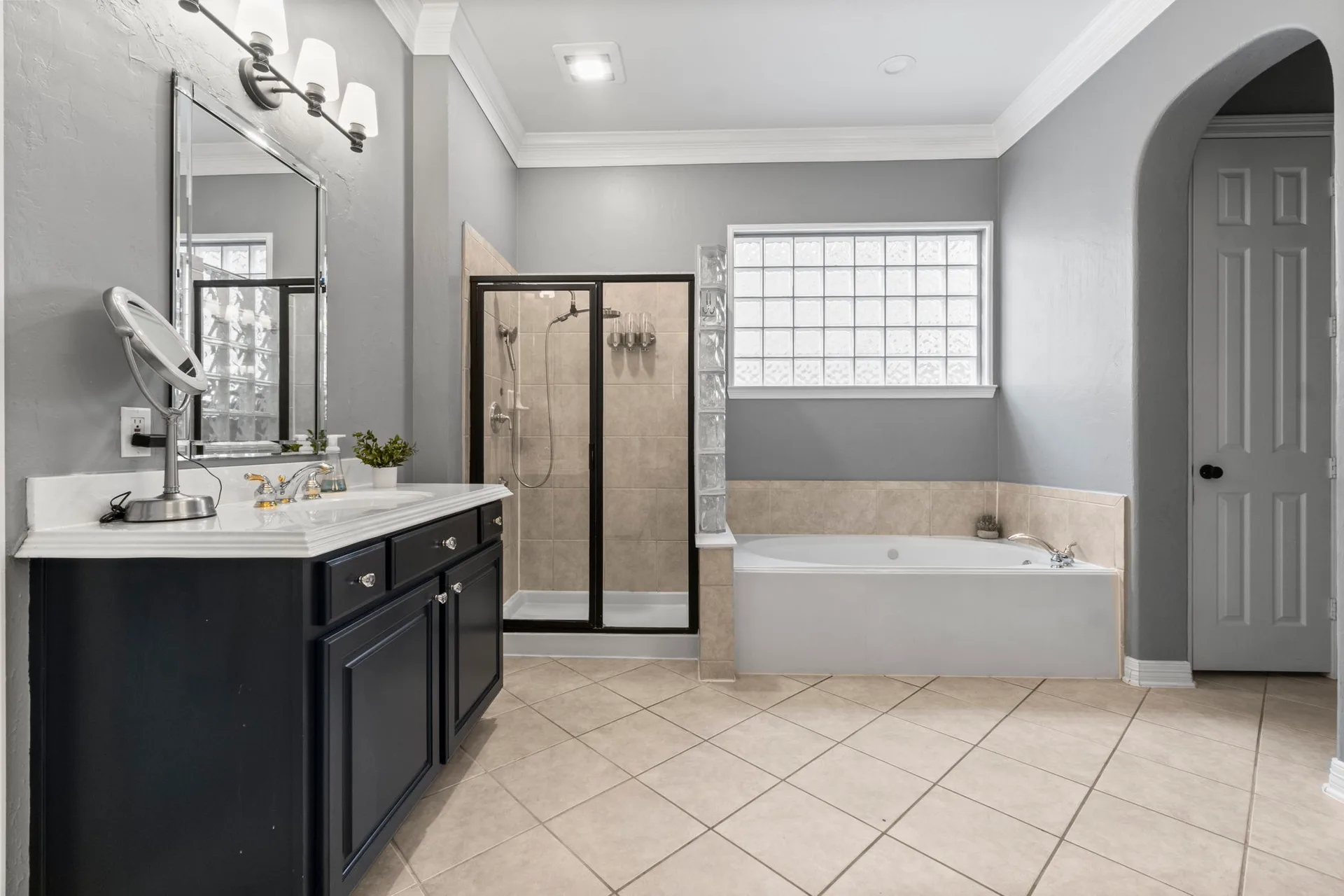 Primary bathroom with navy vanity and soaking tub