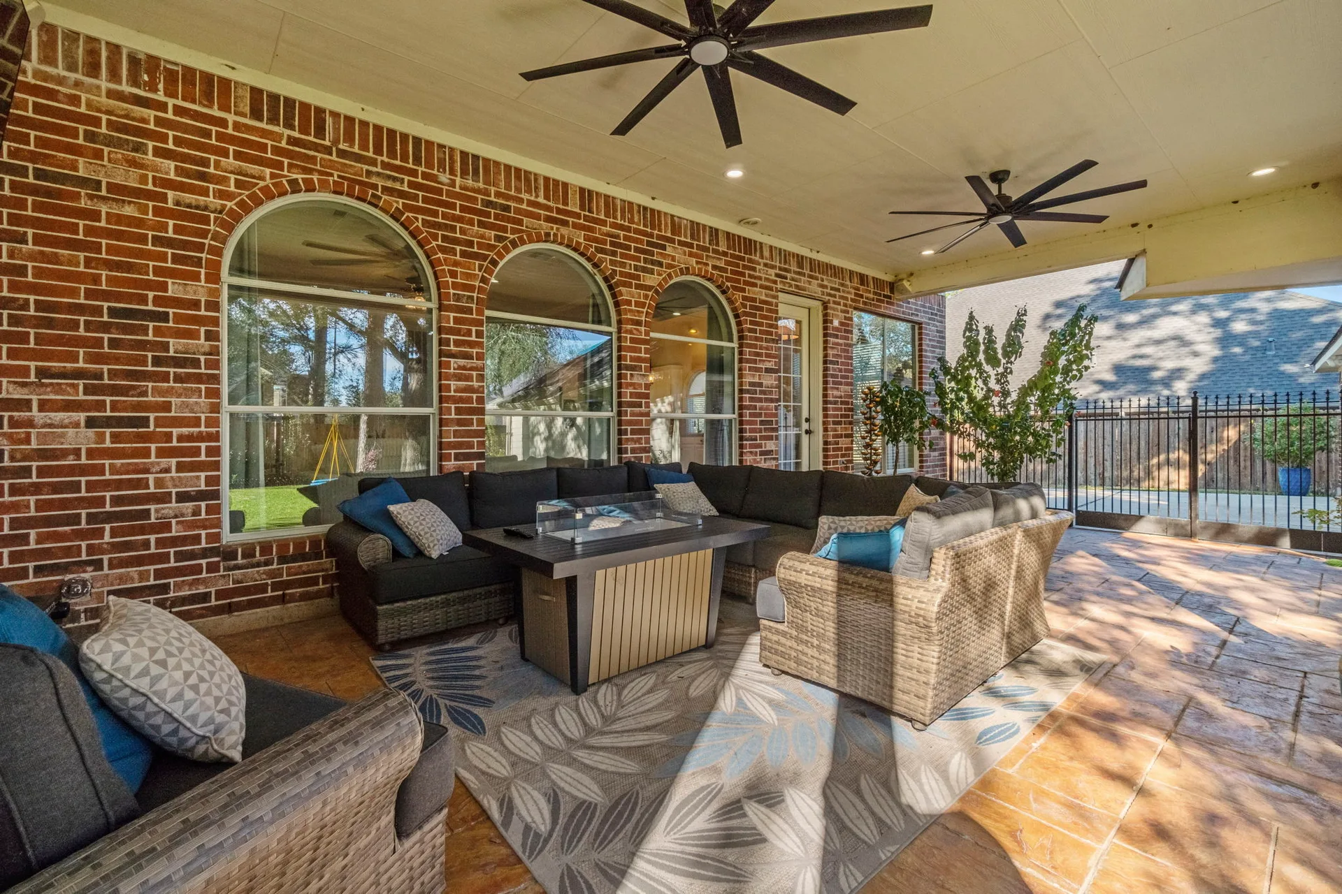Covered patio with stamped concrete flooring and arched windows