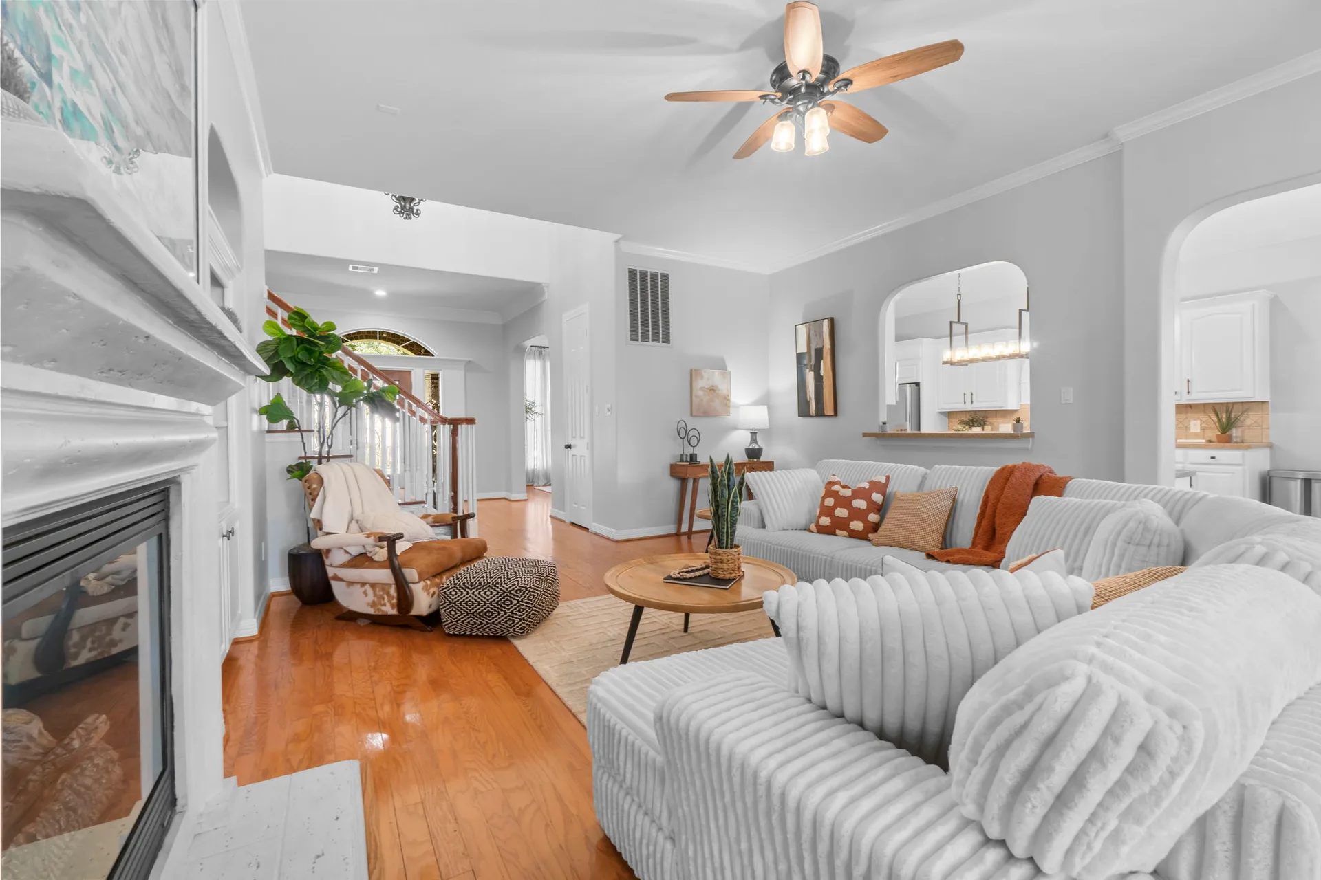Living room open concept transition to kitchen with hardwood flooring and high ceilings