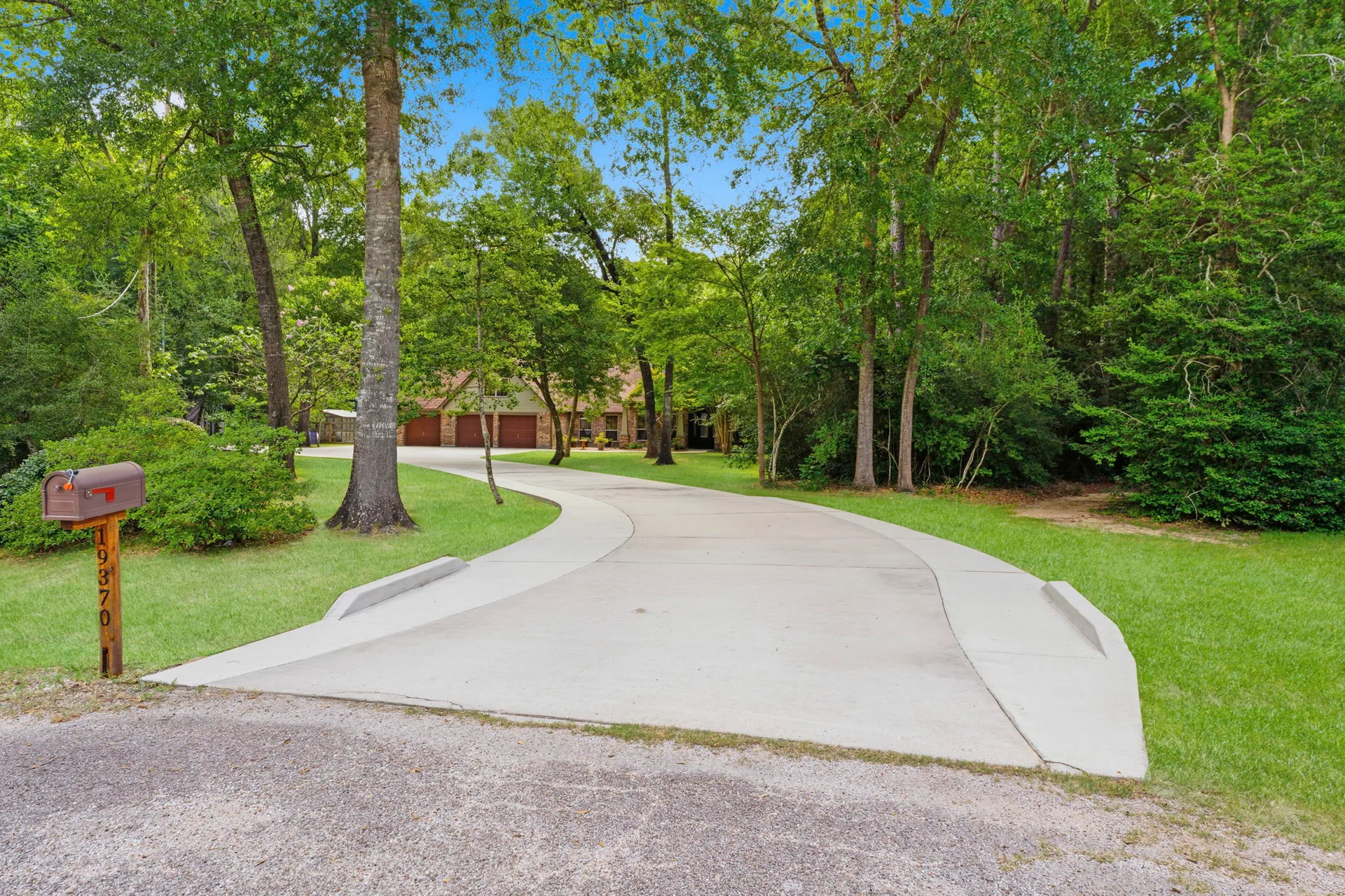 Tree-lined driveway entrance to 19370 Serpenteer Dr